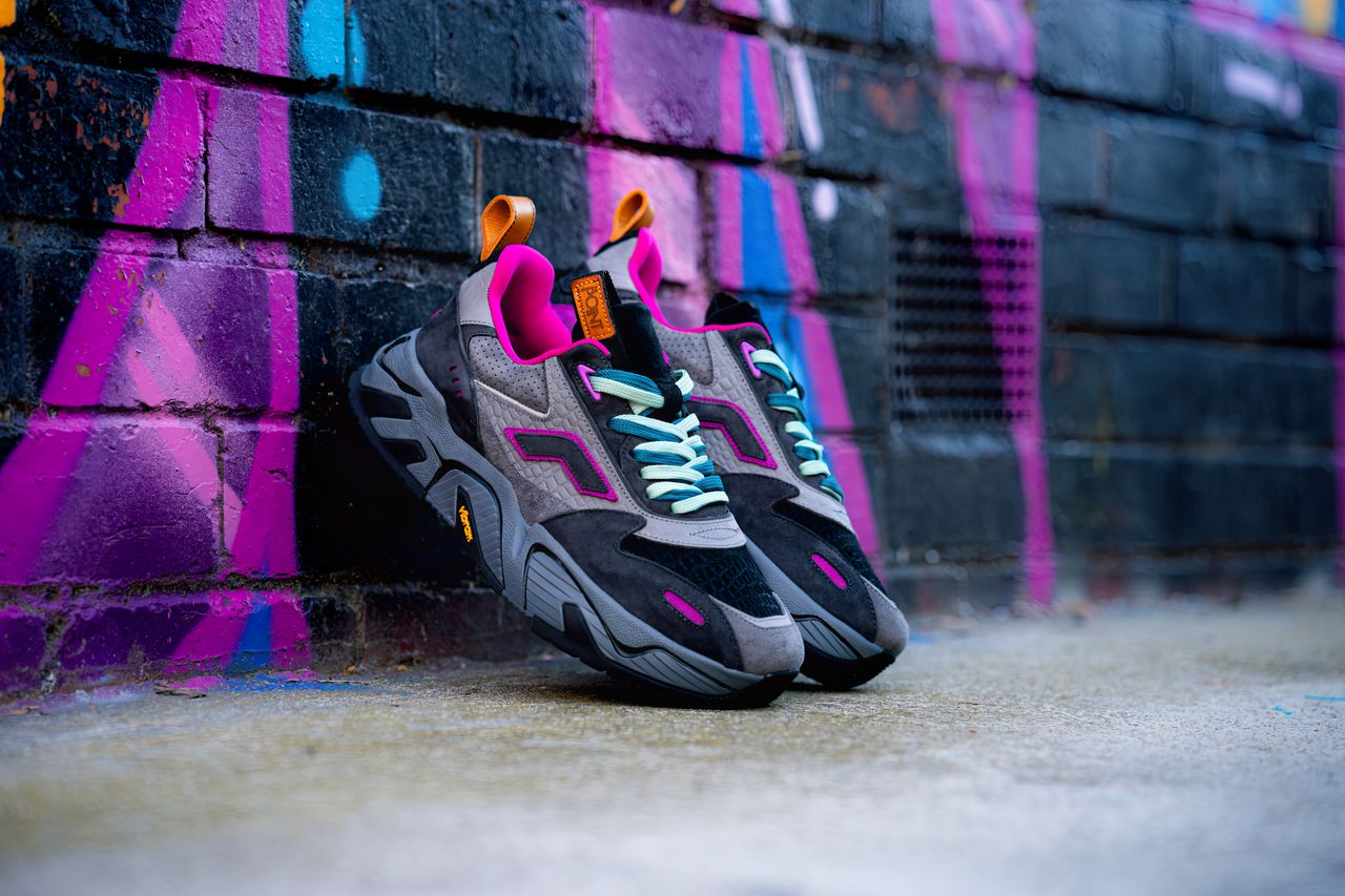mobile-01 Trendy sneakers posed against a colorful graffiti wall, perfect for urban fashion enthusiasts.