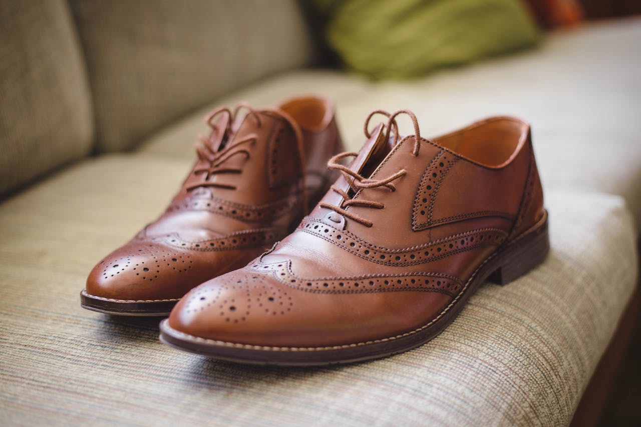 creative Elegant brown pair of leather shoes for men placed on gray surface at home